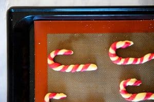 unbaked candy cane cookies on a lined cookie sheet