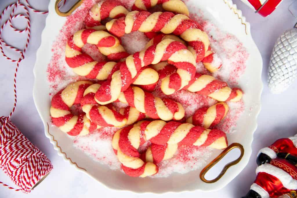 plate with candy cane cookies surrounded by festive decor