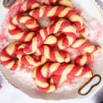 plate with candy cane cookies surrounded by festive decor