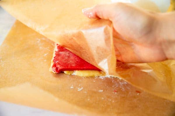 peeling wax paper off two layers of sugar cookie dough