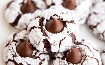 close up of a few chocolate crinkle blossom cookies on a white plate