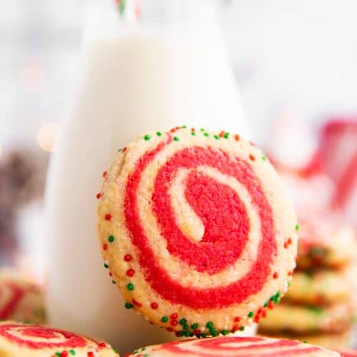 pinwheel cookie leaning against a milk bottle