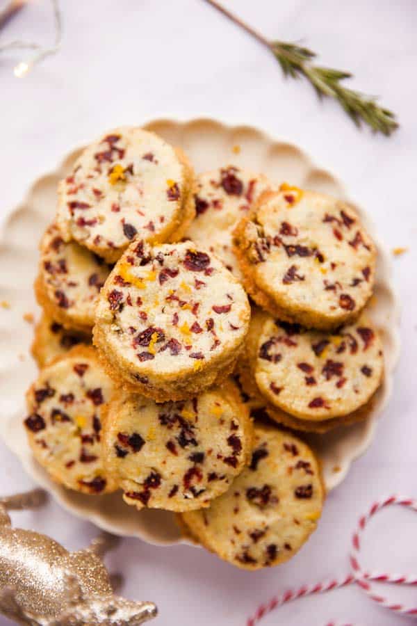 plate filled with cranberry orange shortbread cookies on a marble surface