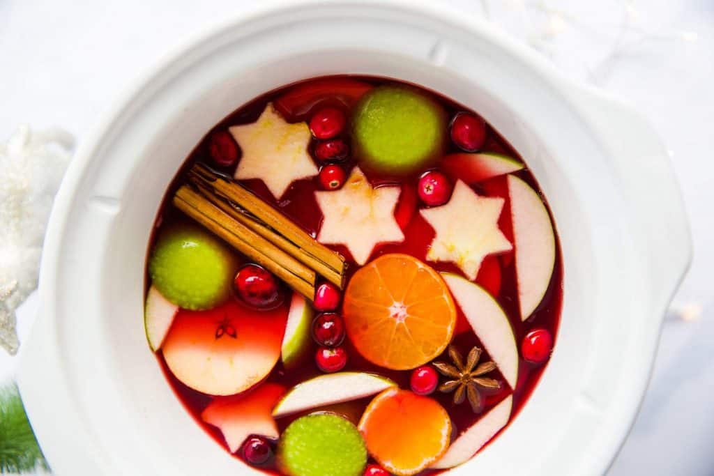 white slow cooker filled with warm Christmas punch