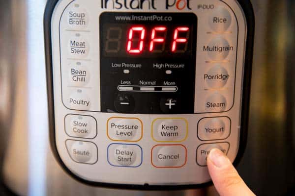 pressing the pressure cooker button on an instant pot