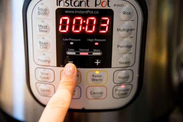 pressing the adjust button on an electric pressure cooker