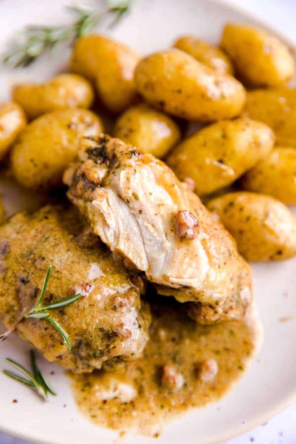cut open chicken thigh on a plate with potatoes