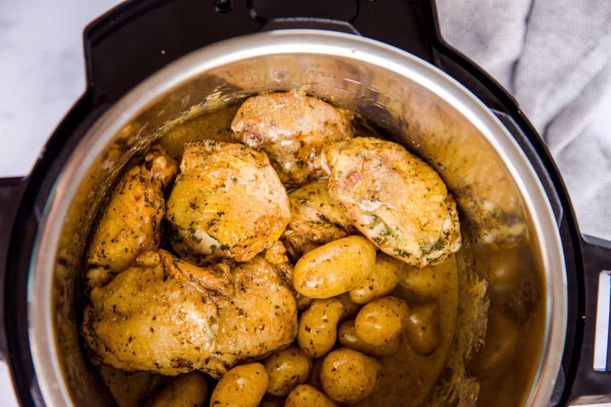 top down view on an instant pot filled with chicken thighs and baby potatoes