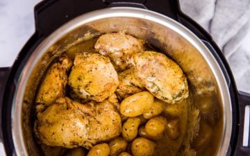 top down view on an instant pot filled with chicken thighs and baby potatoes