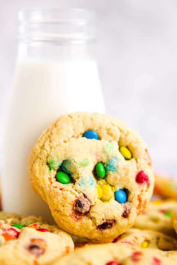 m&m cookie leaning against a bottle of milk