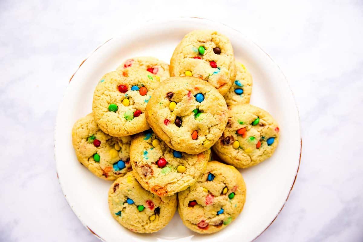 plate with m&m cookies on a white marble surface