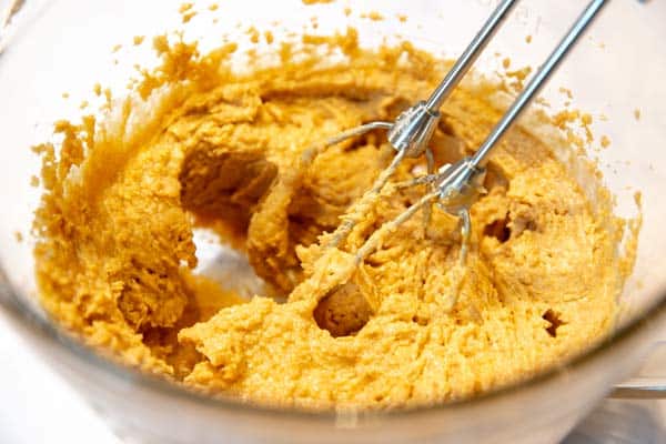 creamed wet ingredients for peanut butter cookies in a bowl with beaters