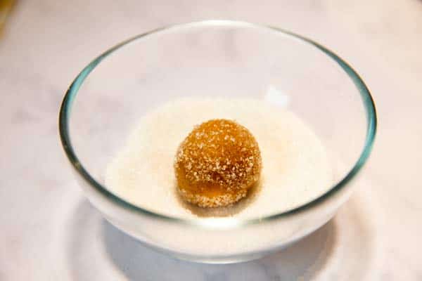 ball of peanut butter cookie dough in a small bowl with granulated sugar