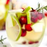 tumbler with lime, cranberry, apple, rosemary and white wine sangria