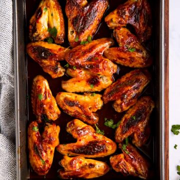 baking dish on wooden board filled with honey wings