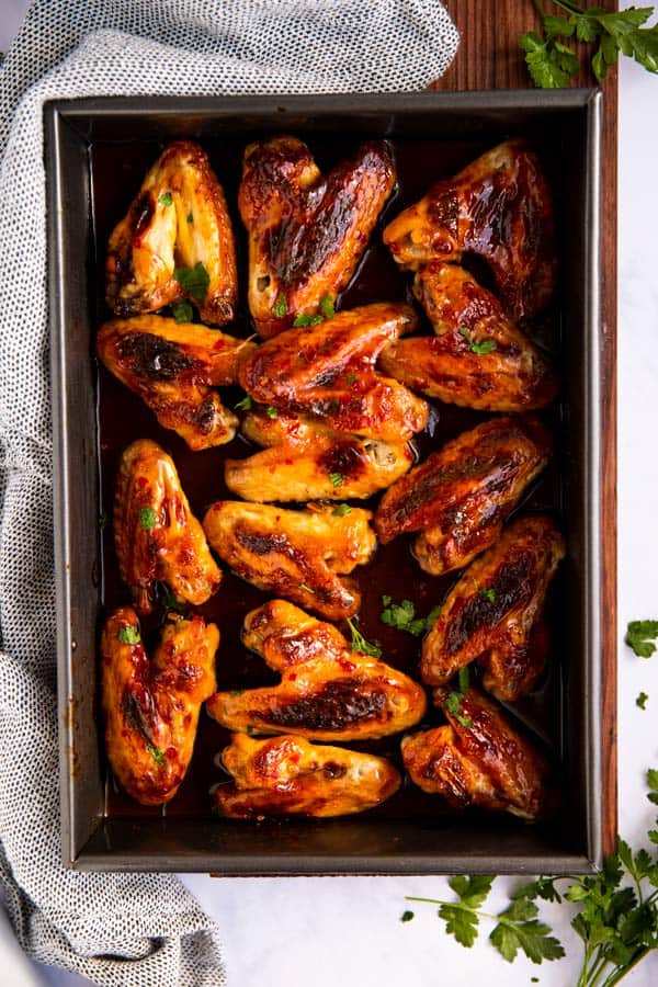 baking dish on wooden board filled with honey wings