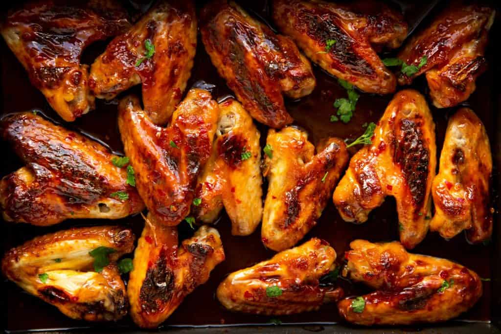 close up photo of a pan filled with sticky glazed chicken wings