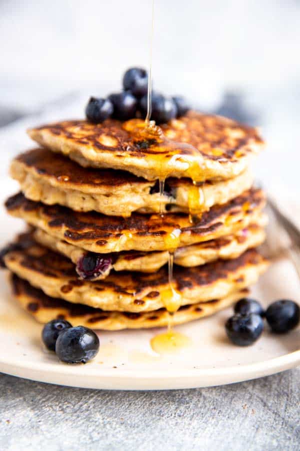 picture of a stack of pancakes with syrup drizzling over