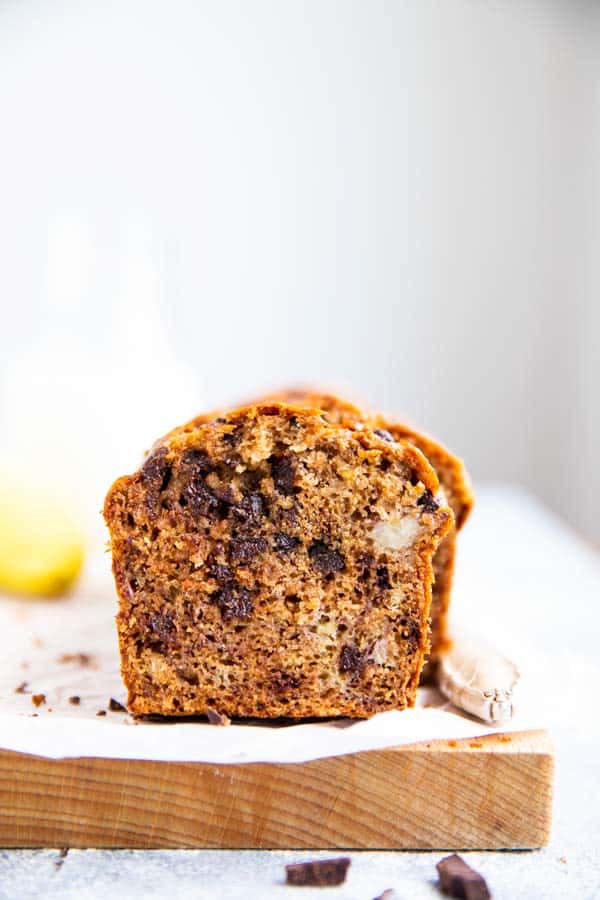 sliced open banana bread with chocolate chips on a wooden board