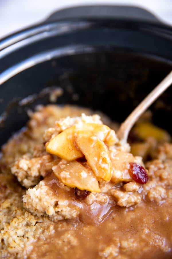 close up photo of cooked apples on top of oatmeal in slow cooker