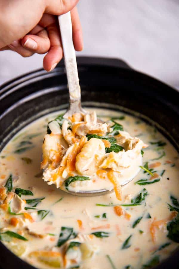ladling chicken gnocchi soup from a crock
