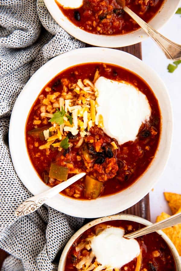 top down view on bowls of turkey chili with sour cream and cheese