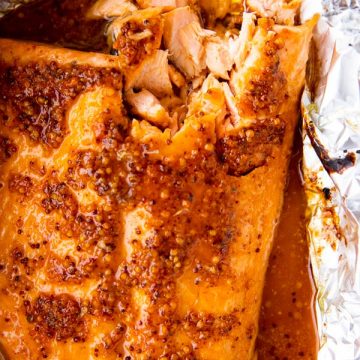 top down view of baked salmon side with maple dijon glaze on a piece of aluminum foil