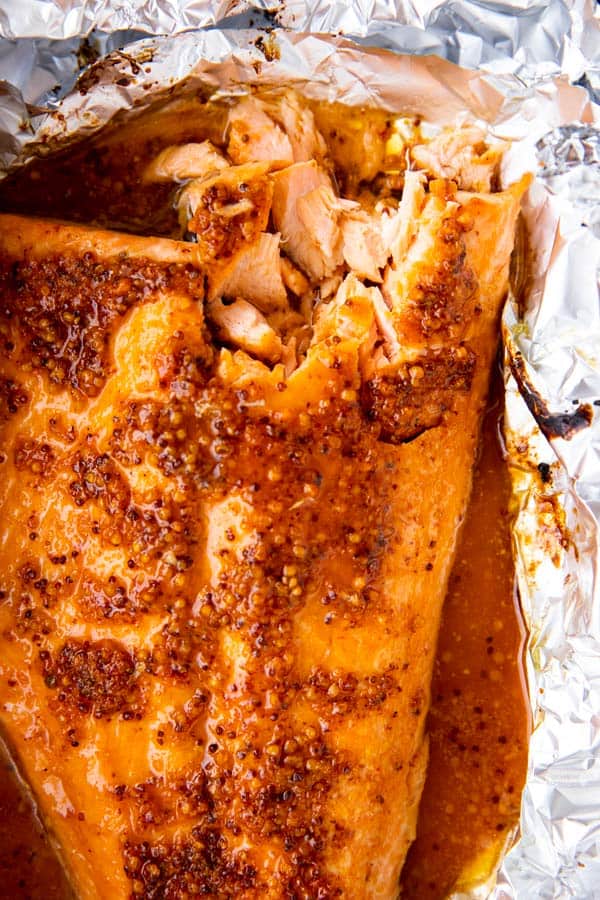 top down view of baked salmon side with maple dijon glaze on a piece of aluminum foil