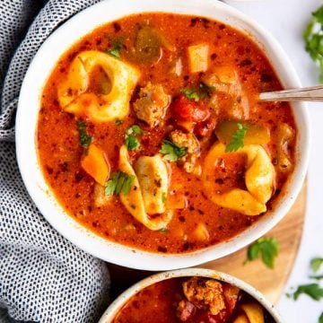 three white soup bowls filled with tortellini soup