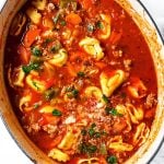 overhead view of sausage tortellini soup in white Dutch oven