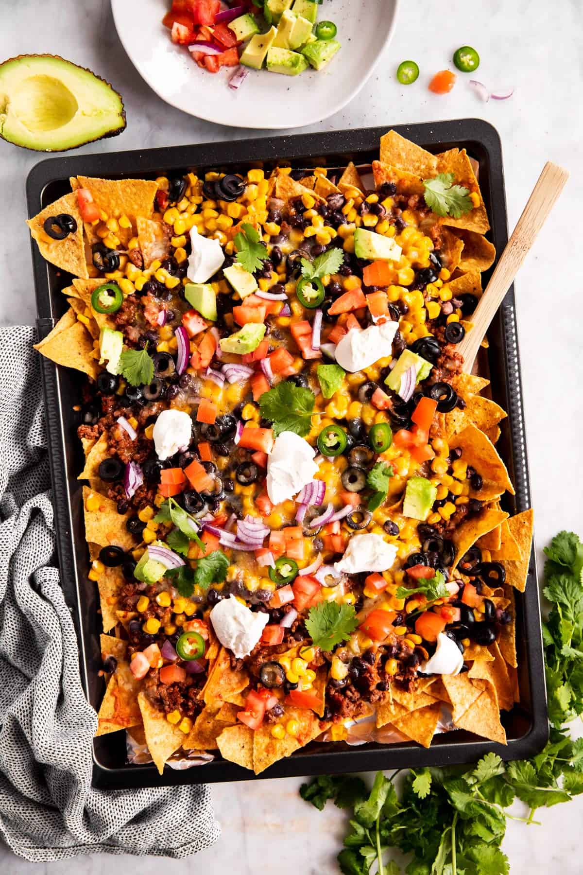 overhead view of nachos on dark colored sheet pan