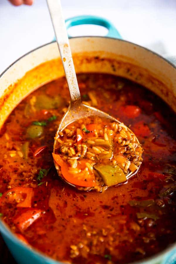 ladle filled with stuffed pepper soup inside pot of soup
