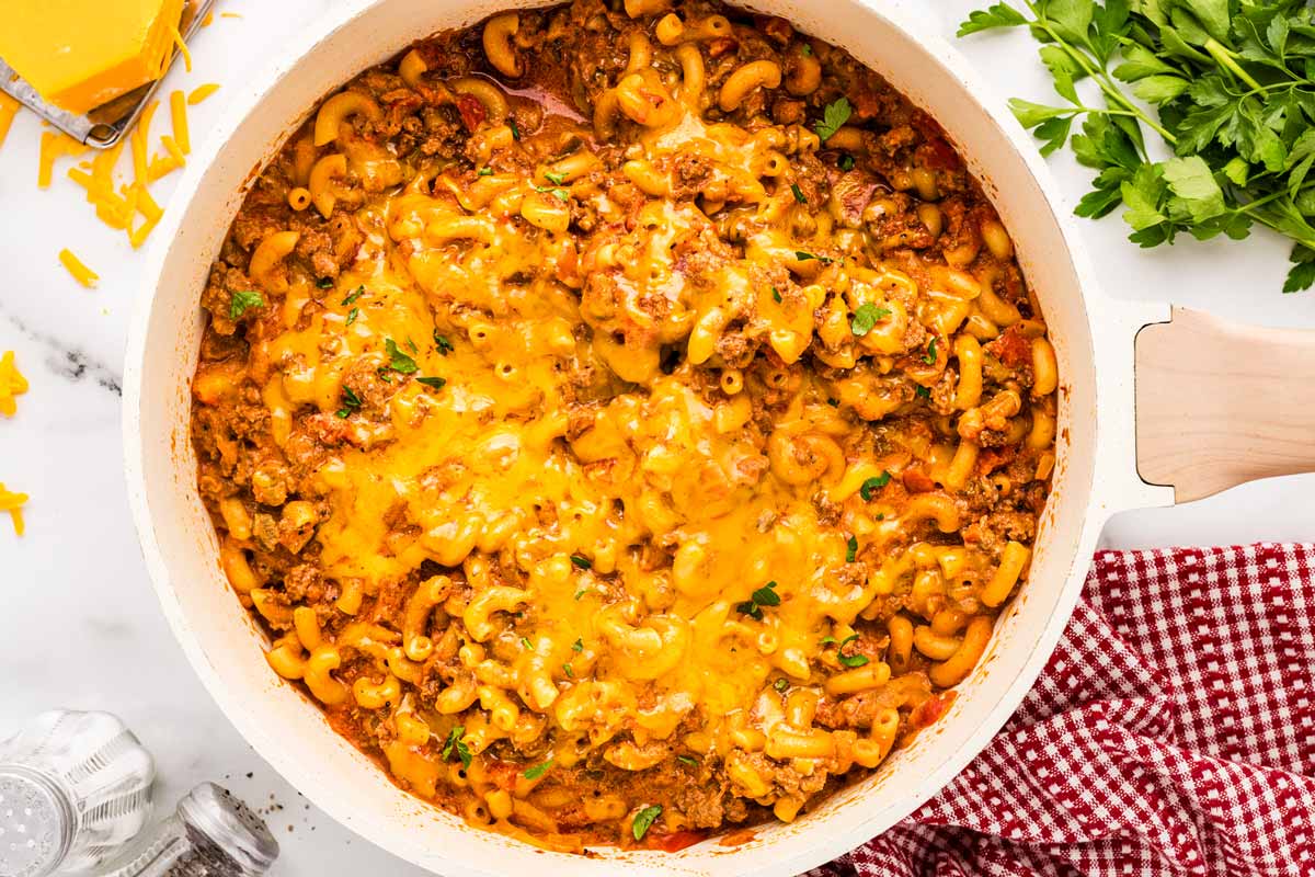 Cooked American Goulash in a skillet with melted cheese.