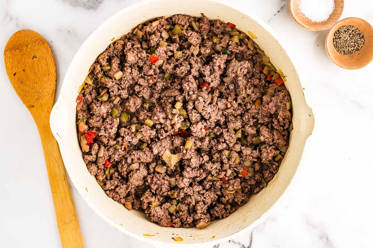 Browning ground beef and vegetables in a skillet.