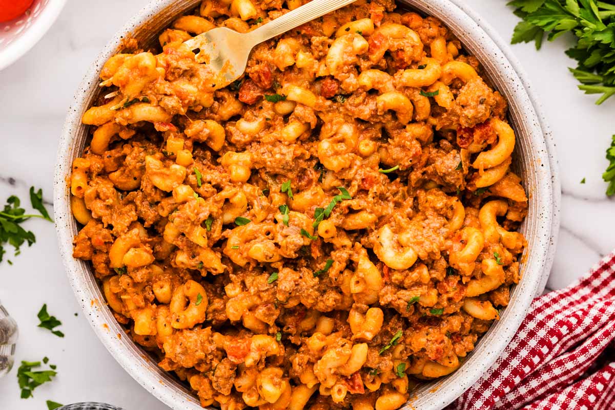 American Goulash in a bowl with a fork stuck in.