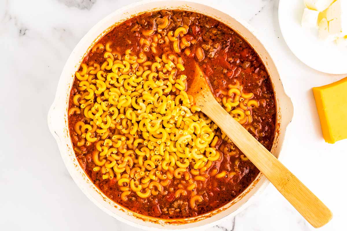 Uncooked American goulash in pan.