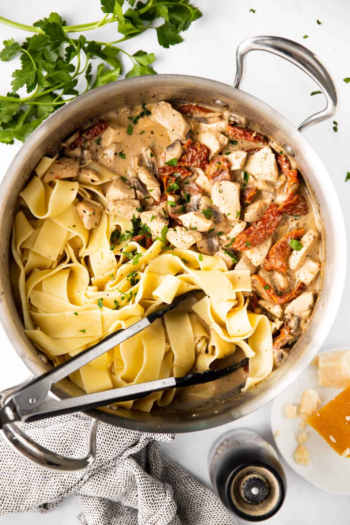 top down view on pan filled with chicken pasta and creamy sun-dried tomato sauce