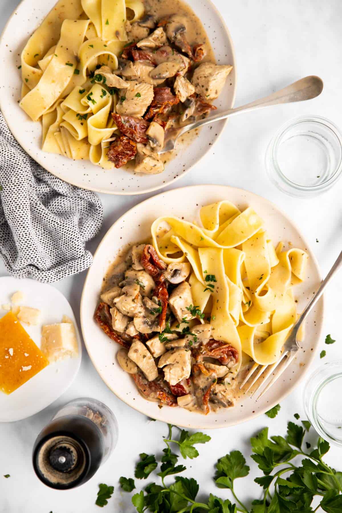 top down view on two plates with chicken pasta