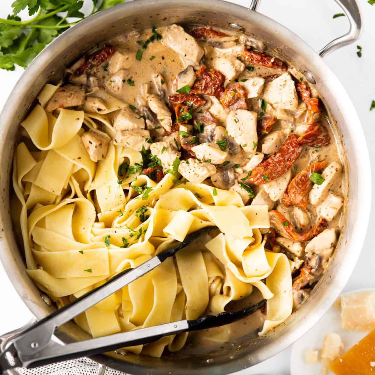 top down view on pan filled with chicken pasta and creamy sun-dried tomato sauce