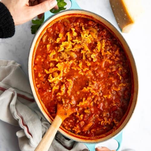 woman holding a pot of lasagna soup