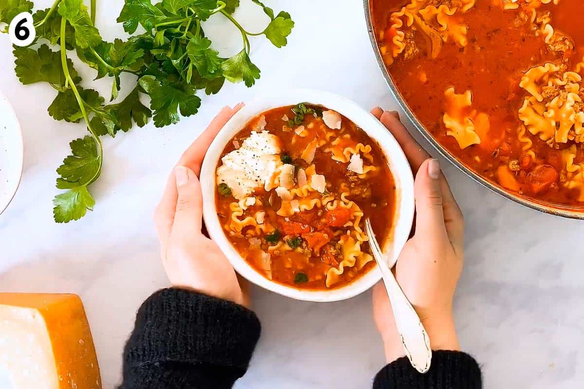 female hands holding bowl with Lasagna Soup