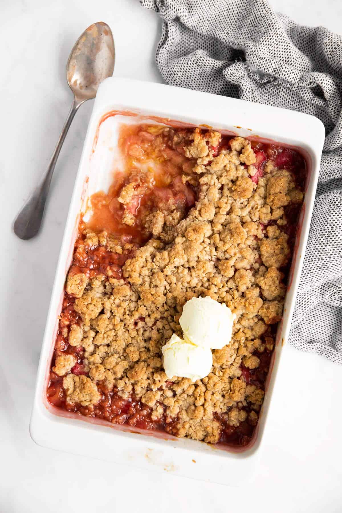 casserole dish with rhubarb crisp and vanilla ice cream