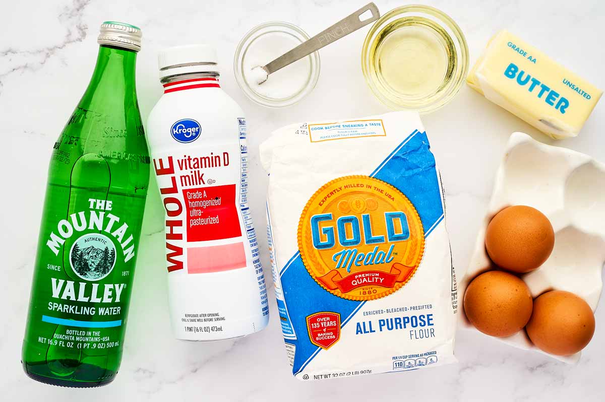 Ingredients for Crêpes on a marble surface.