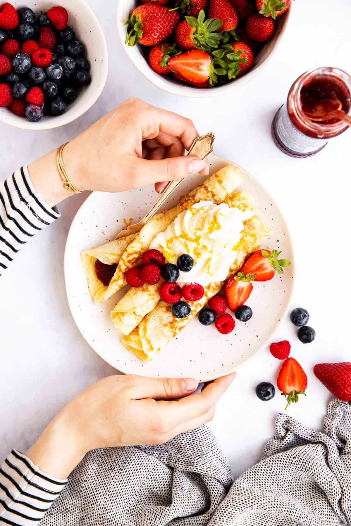 female hands holding plate with crepes