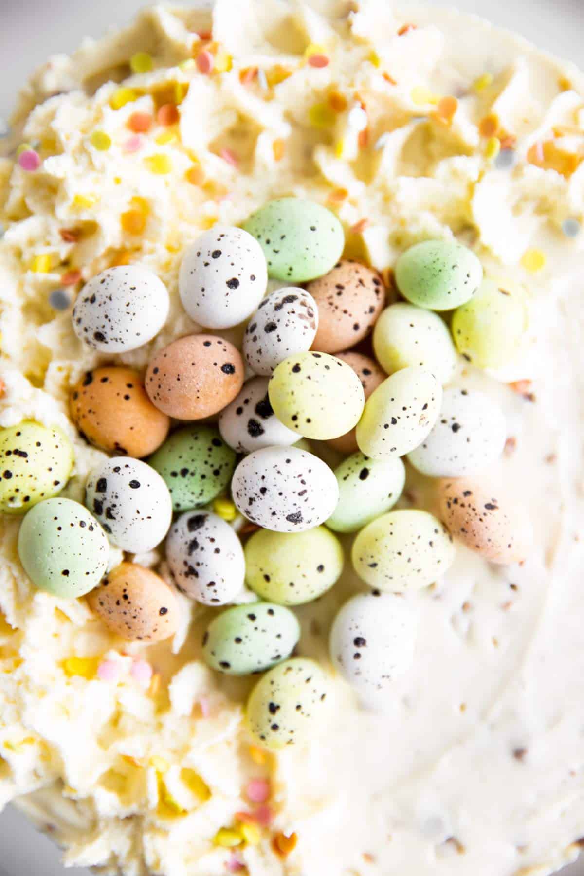 close up photo of mini eggs on top of a cheesecake