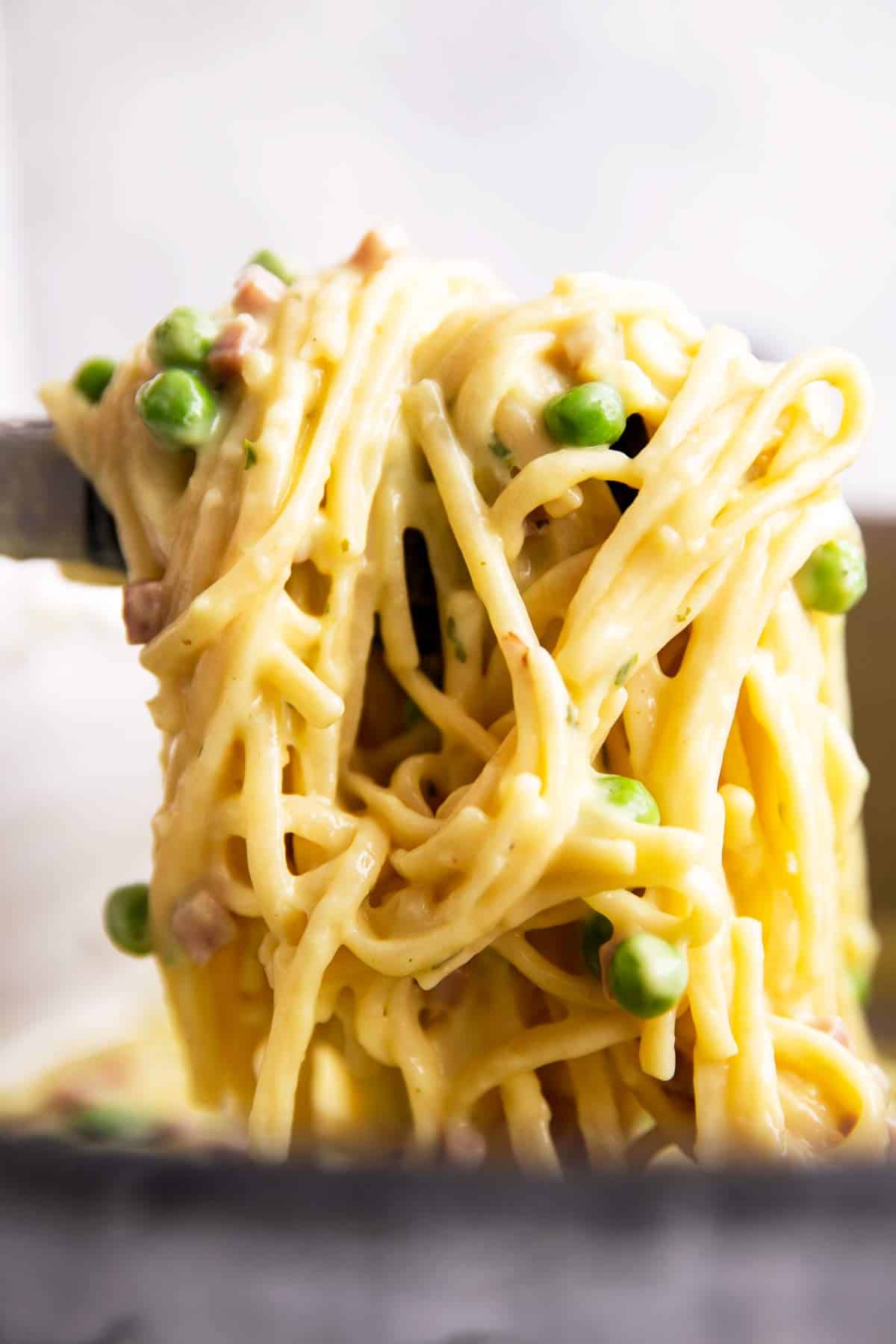 pulling pasta from a pot with kitchen tongs