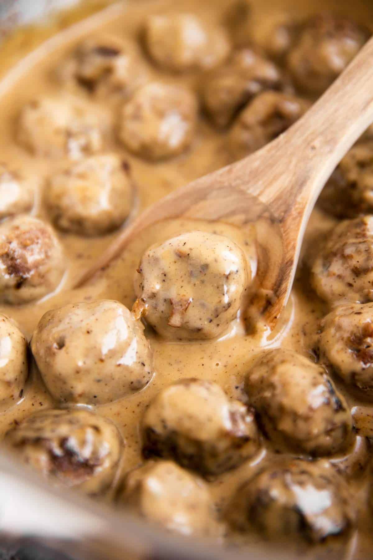 close up photo of meatball covered in gravy