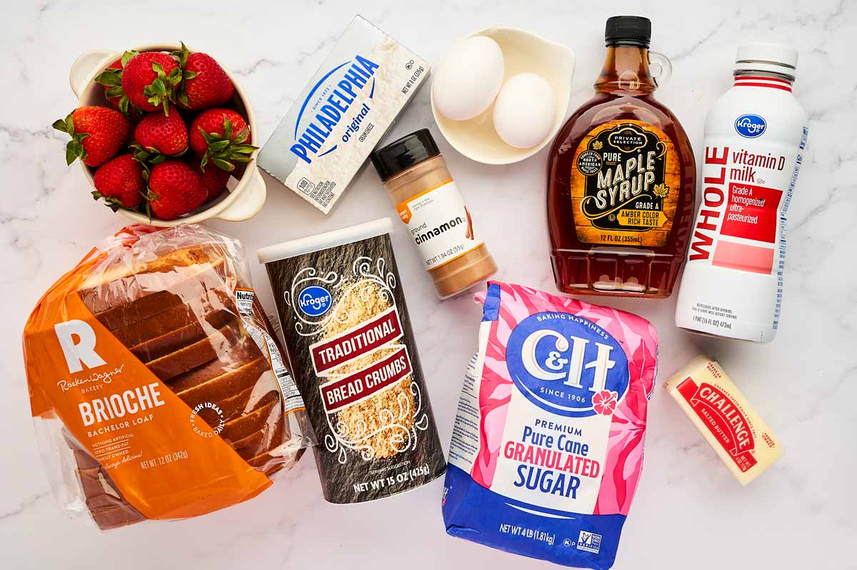 Ingredients for Strawberry Cream Cheese Stuffed French Toast on a marble surface.
