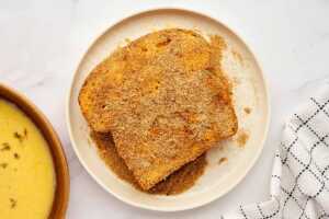 Coating French toast in cinnamon sugar and breadcrumbs.