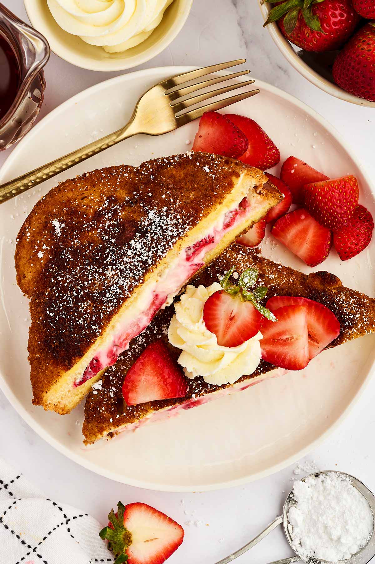 Plated Strawberry Cream Cheese Stuffed French Toast with fresh strawberries.